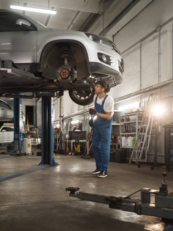 male-mechanic-working-shop-car